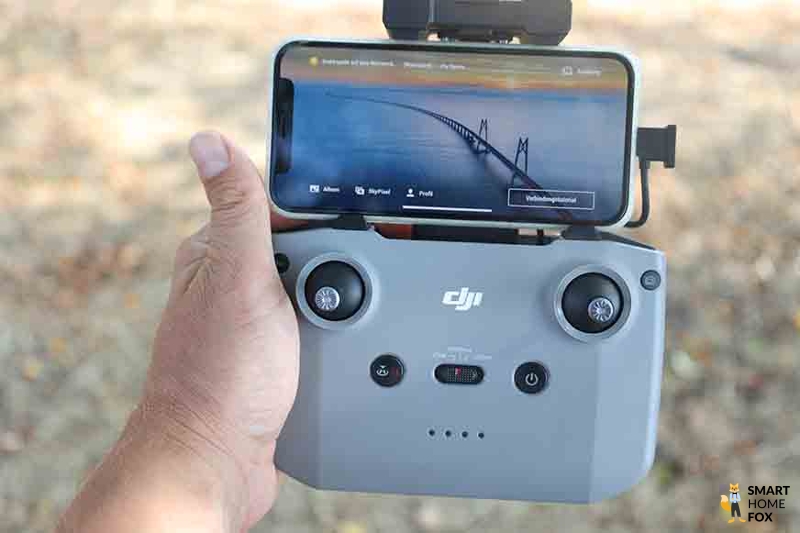 Die DJI RC-N1 Fernsteuerung ist mit einem Smartphone verbunden und die DJI Mini 3 Pro ist Flugbereit.